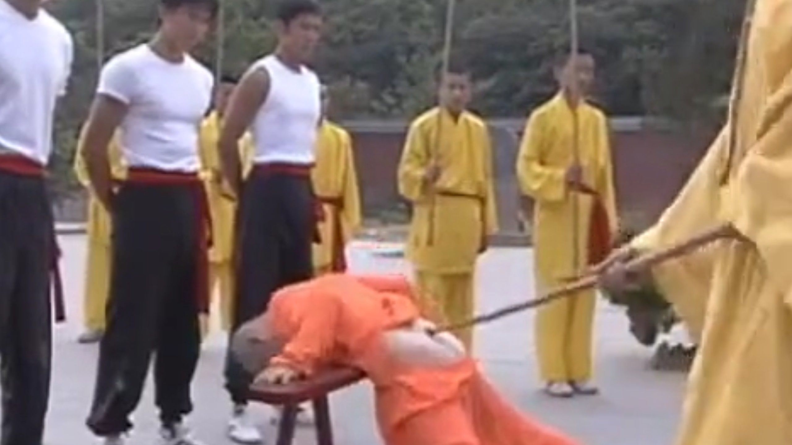 小男孩因为做错事被师傅罚打屁股。