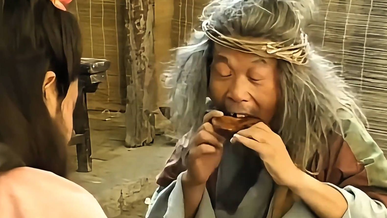 小伙正在吃烧鸡，不料一个老叫花坐下来拿起鸡腿就啃